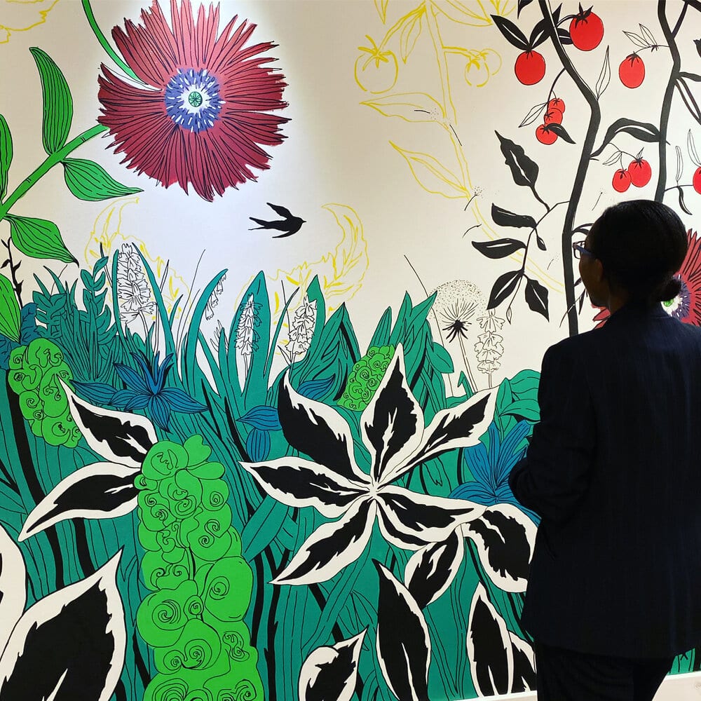 a person looking at a colourful wall mural